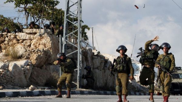 Israeli soldiers throw a flash grenade during clashes with Palestinian demonstrators in the West Bank village of Beit Fajjar, on October 31, 2015 (AFP/Musa Al-Shaer)