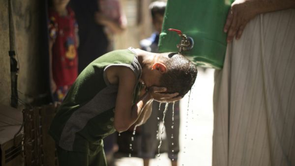 Israel is to supply millions of cubic metres of water to Palestinians including in the Gaza Strip, where a Palestinian boy is seen here cooling off with water from a jerrycan during a heatwave on July 2, 2017. (AFP)