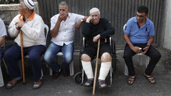 Members of the Shamasneh family sit outside their home after being evicted (Ahmad Gharabli/AFP)