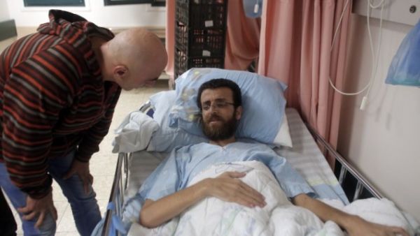 Mohammed al-Qiq, a Palestinian prisoner who carried out hunger strike, talks to a man in a hospital in the northern Israeli town of Afula on February 5, 2016. (AFP/Ahmad Gharabli)