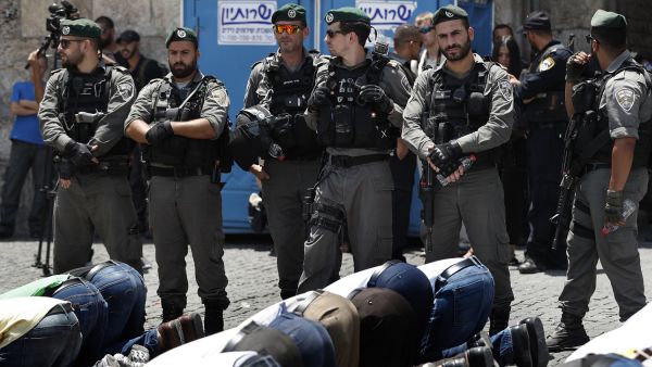 Israeli forces stand guard as Palestinian Muslim worshippers, who refuse to enter Al-Aqsa mosque compound due to newly-implemented security measures by Israeli authorities. (AFP)