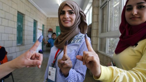 Palestinian women show their ink-stained fingers after casting their ballots during the municipal elections in the West Bank city of Ramallah on May 13, 2017. (AFP/Abbas Momani)