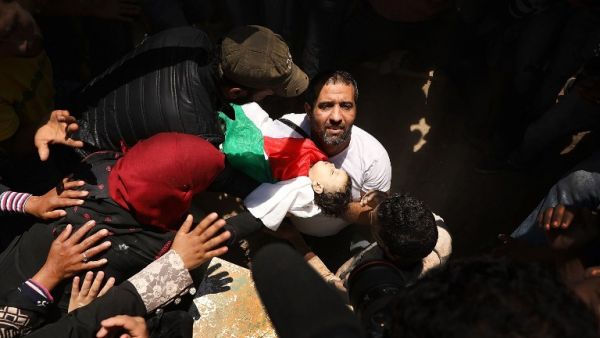 The body of eight-month-old Leila Anwar Ghandoor, who died in hospital, Tuesday morning, from tear gas inhalation, is placed into a grave, May 15, 2018 in Gaza City, Gaza. Anwar was with a relative during the clashes. (AFP/ File Photo)