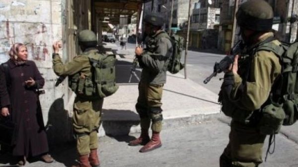 Israeli soldiers stop a Palestinian woman in the Palestinian side of the city of Hebron. (AFP/ File)