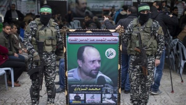 Members of the Ezzedine al-Qassam Brigades, the military wing of Hamas, hold a banner bearing a portrait of Mohammed al-Zoari in Gaza City on December 18, 2016. (AFP/Mahmud Hams)