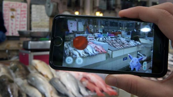 A gamer uses the Pokemon Go application on his mobile in the main fish market in Kuwait City. (AFP/File)