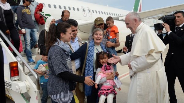 Pope Francis welcomes a group of Syrian refugees to Rome after their plane lands. (AFP/Filippo Monteforte)