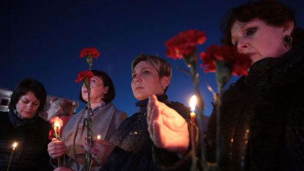 Women hold flowers and lit candles as they take part in a gathering in memory of victims of the blast in the Saint Petersburg metro in Simferopol, Crimea, on April 3, 2017. (AFP/Max Vetrov)