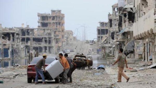 This file photo taken on October 24, 2011 shows Libyans load their belongings into a car in a destroyed street in Sirte. (AFP/File)