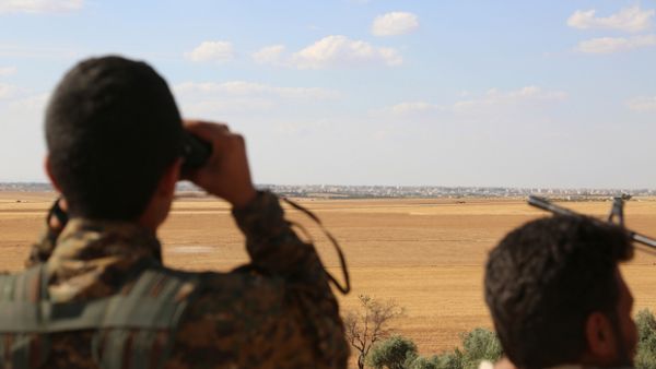 SDF fighters look at the Syrian town Manbij (AFP/File) 
