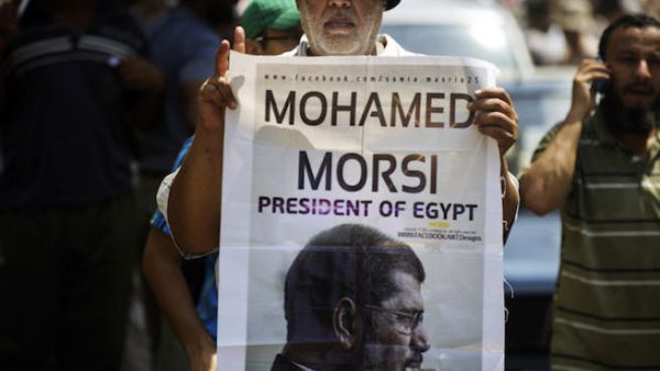A man holds a portrait of ousted president Mohamed Morsi as thousands of his supporters demonstrate for his reinstatement close to the Egyptian cabinet headquarters on July 17, 2013 in Cairo. (Source: AFP/GIANLUIGI GUERCIA)