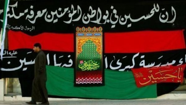 سعودي يمر امام لافتة شيعية في شرق المملكة
