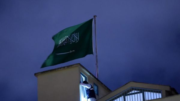 A Turkish forensic stands next to the Saudi flag, on the roof of the Saudi Arabia's consulate in Istanbul on October 15, 2018 during the investigation over missing Saudi journalist Jamal Khashoggi. (BULENT KILIC / AFP)