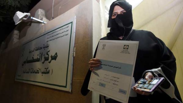 Aljazi al-Hussaini, a candidate for the municipal council in the town of Diriyah, on the outskirts of the Saudi capital Riyadh, shows an electoral campaign licence issued by the central municipal elections committee. (AFP)