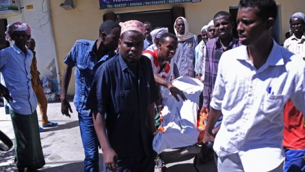 People carry the body of a civilian killed in the al-Shabaab attack on the presidential palace on February 25, 2016. (AFP/Mohamed Abdiwahab)