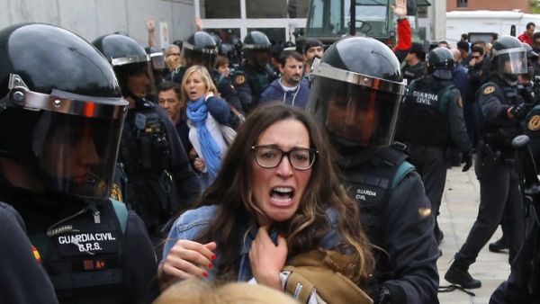 Spanish Guardia Civil guards clash with voters outside a polling station in Sant Julia de Ramis, in the Catalonia region (Raymond Roig/AFP)