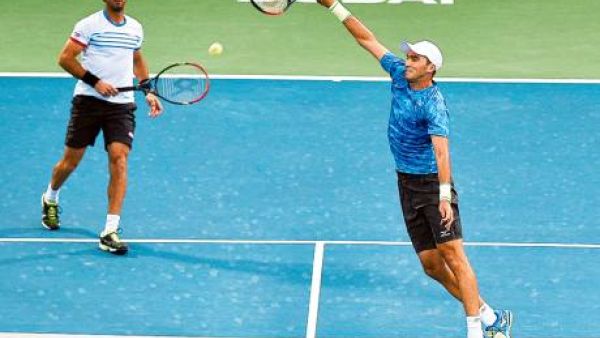 Horia Tecau powers a smash as his partner Jean-Julien Rojer watches during their men’s doubles final against Rohan Bopanna and Marcin Matkowski atDubai Tennis Stadium. (Photo: Ahmed Ramzan/Gulf News)