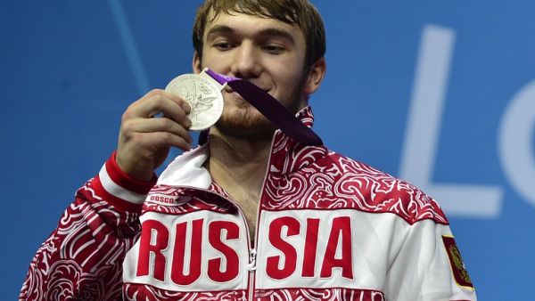 Russia's Apti Aukhadov poses on the podium with his silver medal, during the men's 85kg group A weightlifting event of the London 2012 Olympic Games at The Excel Centre in London on August 3, 2012. YURI CORTEZ / AFP