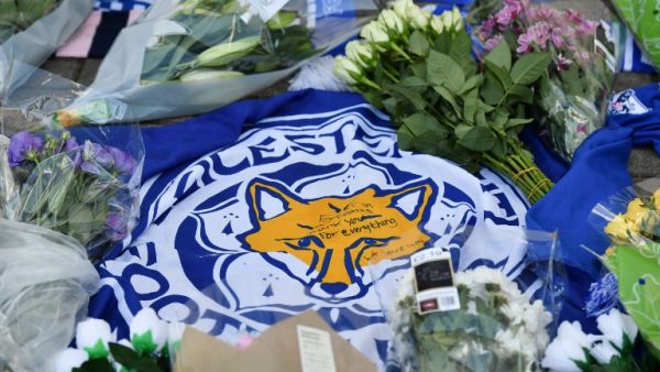A flag showing the Leicester City Football Club's Fox logo with a message of thanks is seen in a growing pile of tributes outside Leicester City Football Club's King Power Stadium in Leicester, eastern England, on October 28, 2018.
Ben STANSALL / AFP