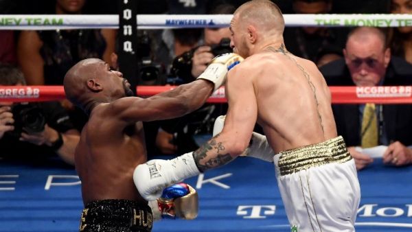 LAS VEGAS, NV - AUGUST 26: (L-R) Floyd Mayweather Jr. throws a punch at Conor McGregor during their super welterweight boxing match on August 26, 2017 at T-Mobile Arena in Las Vegas, Nevada. Ethan Miller/Getty Images/AFP Ethan Miller / GETTY IMAGES NORTH AMERICA / AFP
