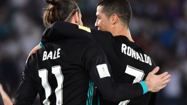 Real Madrid's Welsh forward Gareth Bale (L) is congratulated after scoring by teammate Portuguese forward Cristiano Ronaldo (R) during the FIFA Club World Cup semi-final match in the Emirati capital Abu Dhabi on December 13, 2017.
GIUSEPPE CACACE / AFP
