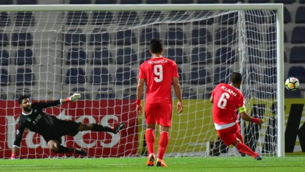 Tractorsazi Tabriz's midfielder Mehdi Kiani (R) kicks and misses a penalty during the AFC Champions League football match Tractorsazi Tabriz vs Al Ahli at the Tahnoun Bin Mohammed Stadium in Al Ain on April 3, 2018.
GIUSEPPE CACACE / AFP