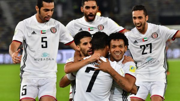 Al-Jazira's Emirati forward Ali Mabkhout (C, front) embraces his teammates Moroccan Mbark Boussoufa (C-L, behind) and Brazillian Romarinho (C-R, behind), as they celebrate after him scoring a goal against Urawa Reds during their FIFA Club World Cup quarter-final match at Zayed Sports City Stadium in the Emirati capital Abu Dhabi on December 9, 2017.
GIUSEPPE CACACE / AFP