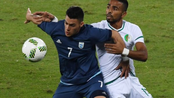 Argentina player Cristian Pavon (L) vies for the ball with Algeria player Houari Ferhani during the Rio 2016 Olympic Games men's First Round Group D football match, at the Olympic Stadium in Rio de Janeiro on August 7, 2016.
VANDERLEI ALMEIDA / AFP