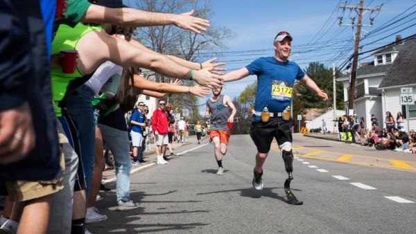 FRAMINGHAM, MA - APRIL 17: Spectators give high fives to a disabled runner as he makes his way past the 6 mile mark of the Boston Marathon on April 17, 2017 in Framingham, Massachusetts. (Kayana Szymczak/Getty Images)
Kayana Szymczak / GETTY IMAGES NORTH AMERICA / AFP