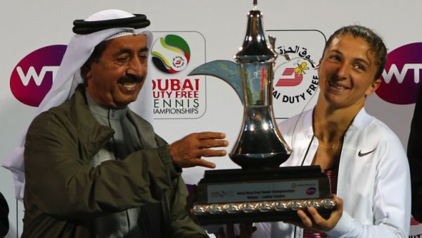 Italian tennis player Sara Errani (R) and Sheikh Hasher bin Maktoum, head of the UAE tennis federation, pose with the winner's trophy after Errani beat Czech player Barbora Strycova in the semi-final WTA tennis match of the Dubai Duty Free Tennis Championships, on February 20, 2016. Sara Errani (ITA) beat Barbora Strycova (CZE) 6-0, 6-2