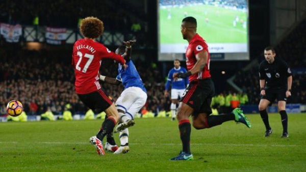 مروان فيلايني (يسار) يعرقل إدريسا غاي ليحتسب الحكم مايكل أوليفر ركلة الجزاء التي سجل إيفرتون منها هدف التعادل