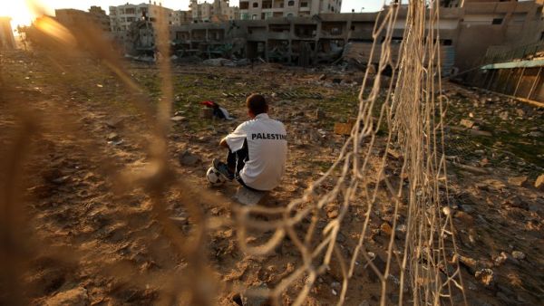 Palestinian runner and football player Bilal Abu Samaan, 20, sits in the rubble of the bombed Palestine Stadium in Gaza City on November 28, 2012. The stadium was bombed by the Israeli airforce during a conflict between the ruling Hamas party and the Israeli military between 14 and 21 November 2012. AFP PHOTO / PATRICK BAZ
PATRICK BAZ / AFP
