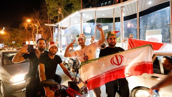 Iranians celebrate on the streets of Tehran early on June 13, 2017, after their national football team won the 2018 World Cup qualifying football match between Iran and Uzbekistan. Iran become the third team assured of a berth in the 2018 World Cup finals along with hosts Russia and Brazil after a 2-0 win over Uzbekistan in Tehran on June 12.
STRINGER / AFP