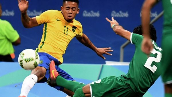 Brazil's player Gabriel Jesus (L) and Iraq's Dhurgham Ismael vie for the ball during their Rio 2016 Olympic Games Men's First Round Group A football match, at the Mane Garrincha Stadium in Brasilia on August 7, 2016.
EVARISTO SA / AFP