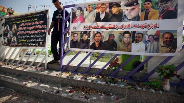 An Iraqi man walks past a poster bearing the portraits of the victims at a cafe, that was popular with local fans of Spain's Real Madrid football club, in the Balad area, north of the capital Baghdad, on May 14, 2016, a day after a deadly raid claimed by Islamic State group militants. At least 16 people were killed and 30 wounded, including several members of the security forces, in the attack in the town of Balad and the ensuing chase, officials said.
AHMAD AL-RUBAYE / AFP