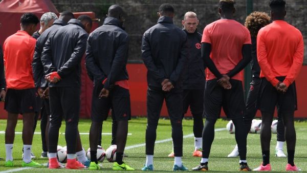 Manchester United's English striker Wayne Rooney (4R) stands with teammates as they observe a minute's silence for the victims of yesterday's terror attack at the Ariana Grande concert at the Manchester Arena, during a team training session at the club's training complex near Carrington, west of Manchester in north west England on May 23, 2017, ahead of their UEFA Europa League final football match against Ajax.
Paul ELLIS / AFP
