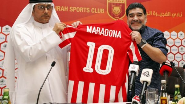 Former Argentinian footballer and manager Diego Armando Maradona (R) holds a jersey of the football club Fujairah FC, bearing his name on the reverse, during a press conference where he was announced as the upcoming manager for the team, in the Gulf emirate of Fujairah on May 14, 2017.
STRINGER / AFP