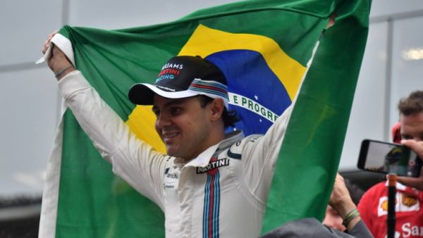 Williams Martini Racing's Brazilian driver Felipe Massa, holding his country's flag, greets fans after his final appearance at Interlagos circuit before retirement, at the end of the Brazilian Grand Prix in Sao Paulo, Brazil, on November 13, 2016.
Nelson Almeida / AFP