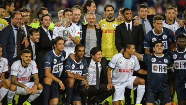 Match For Peace's Argentinian defender Javer Zanetti (C white up) holds the trophy with Match For Peace's players team at the end of their intereligious " Match for Peace " football game on September 1, 2014 at Rome's Olympic stadium. AFP PHOTO / ANDREAS SOLARO