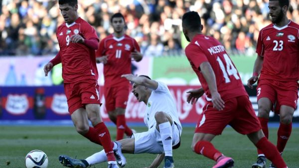 Palestinian forward Tamer Seyman (L) vies for the ball with Algerian Zinedine Ferhat (C) during a friendly match between the Palestinian and Algerian Olympic football teams at the Stade du 5 Juillet 1962 stadium in Algiers on February 17, 2016. 