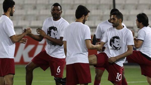 Qatar's national team players wear t-shirts bearing portraits of Emir Sheikh Tamim bin Hamad Al-Thani, in support the Qatari leader in the ongoing diplomatic crisis surrounding Qatar and other Gulf countries as they warm up prior to their World Cup 2018 Asia qualifying football match between Qatar and South Korea at the Jassim Bin Hamad stadium in Doha on June 13, 2017.
KARIM JAAFAR / AFP