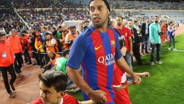 FC Barcelona legend Ronaldinho enters the pitch during the Classico of Legends football match between Barcelona and Real Madrid on April 28, 2017, at Camille Chamoun stadium in the Lebanese capital Beirut.
STRINGER / AFP
