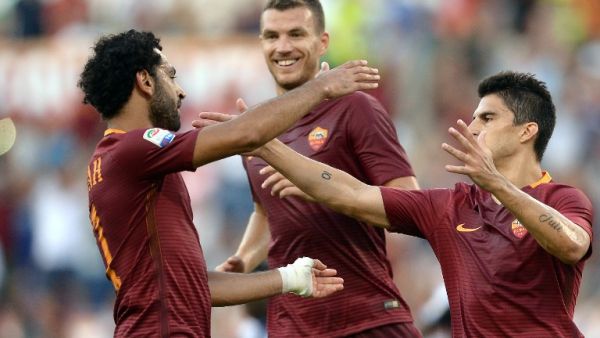 Roma's Argentinian midfielder Diego Perotti (R) celebrates with his teammates Egyptian midfielder Mohamed Salah (L) and Macedonian forward Edin Dzeko (rear C) after scoring during the Italian Serie A football match between Roma and Udinese at the Olympic Stadium in Rome on August 20, 2016.
FILIPPO MONTEFORTE / AFP