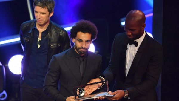British singer-songwriter Noel Gallagher (L) and former Ivory Coast player Didier Drogba present Liverpool and Egypt forward Mohamed Salah (C) with the trophy for the FIFA Puskas Award for 2018, the best goal scored between July 2017 and July 2018 during The Best FIFA Football Awards ceremony, on September 24, 2018 in London.
Ben STANSALL / AFP