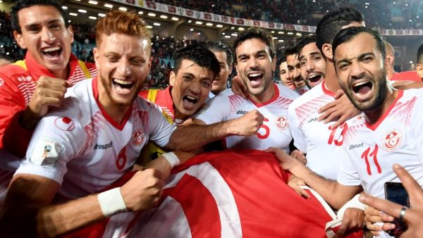 Players of the Tunisian national football team celebrate with their national flag after qualifying for the 2018 World Cup finals after drawing their qualifiers match against Libya at the Rades Olympic Stadium in the capital Tunis on November 11, 2017.
FETHI BELAID / AFP