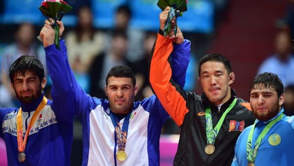 Gold medalist Iran's Reza Yazdani (2nd L) poses with silver medalist Kyrgyzstan's Magomed Musaev (L) and bronze medalists Mongolia's Khuderbulga Dorjkhand (2nd R) and Kazakhstan's Mamed Ibragimov (R) in the medal ceremony of the men's freestyle 97 kg wrestling event during the 2014 Asian Games at the Dowon Gymnasium in Incheon on September 28, 2014. AFP PHOTO / JUNG YEON-JE
JUNG YEON-JE / AFP