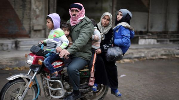 A Syrian family ride a motorbike in the town of Saqba, on the outskirts of the capital Damascus. (AFP/AMER ALMOHIBANY)
