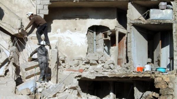 Rescuers climb on the rubble of a destroyed building following an airstrike in the northern Syrian city of Aleppo on December 24, 2013. Syrian warplanes have killed more than 330 people in a nine-day bombing campaign. [AFP]