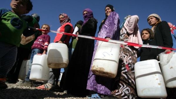 Syrian-Kurdish refugee women wait to fill up water containers at the Quru Gusik (Kawergosk) refugee camp, 20 kilometers east of Arbil, the capital of the autonomous Kurdish region of northern Iraq. [AFP]