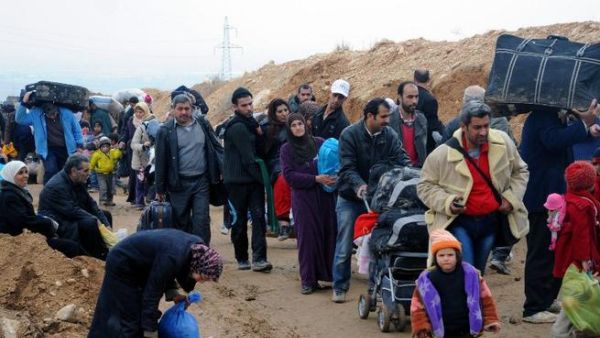 Residents of the industrial city of Adra, northeast of Damascus, walking as they are evacuated from the city, which is strategically located on a main road into the capital, due to fierce fighting between government troops and opposition forces. [AFP]